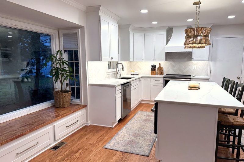 Remodeled kitchen in Millersville, MD with a built-in window seat with drawers, white cabinets and oak floors